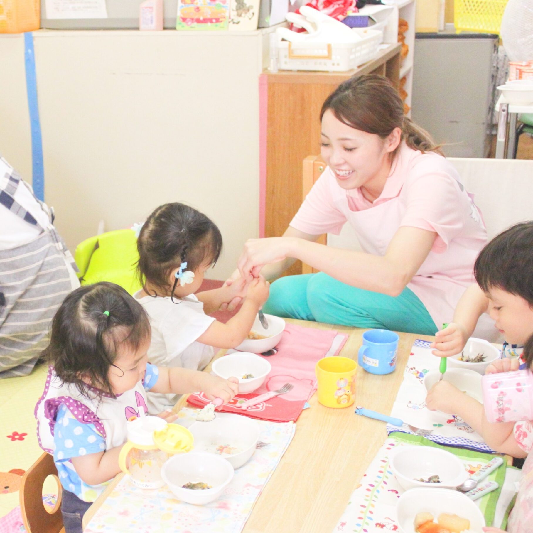 保育士が子どもたちと一緒に給食を楽しむ様子。食べる喜びと優しい関わりがあふれるすずらん幼児園の食事風景。